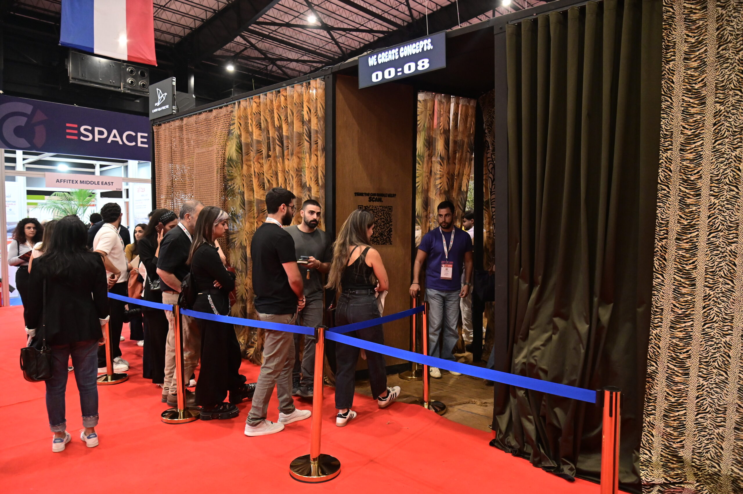 Queue at the booth entrance under the We Create Concepts screen